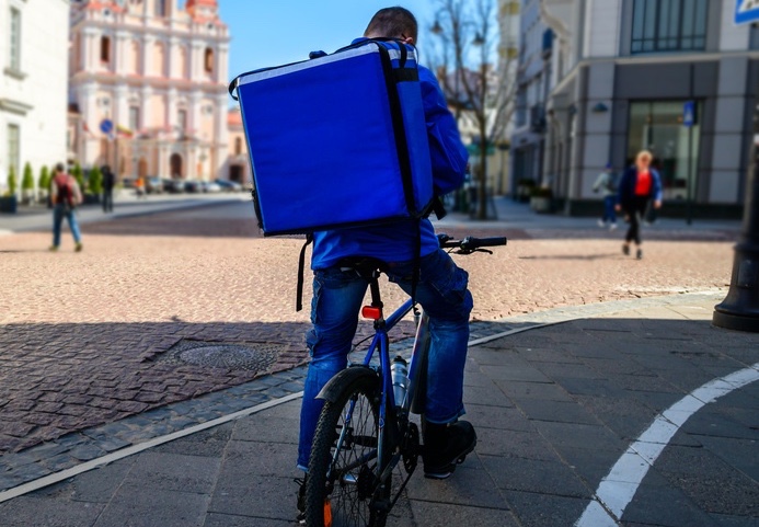Un livreur de repas à vélo qui consulte son smartphone